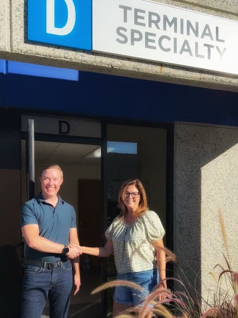 Isaac Tipton and Joan Forrest shaking hands outside the Terminal Specialty office